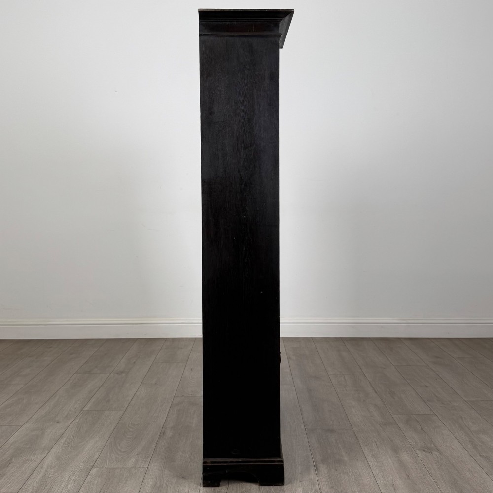 An ebonised oak bureau bookcase featuring an asymmetrical design with a glazed door cabinet, a slanted fall-front writing surface, open shelving, and a heart cutout crest. View IX