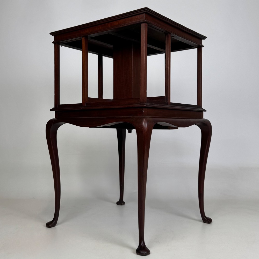 A dark mahogany revolving bookcase featuring a two-tier rotating upper section supported by slender cabriole legs ending in pad feet. View II