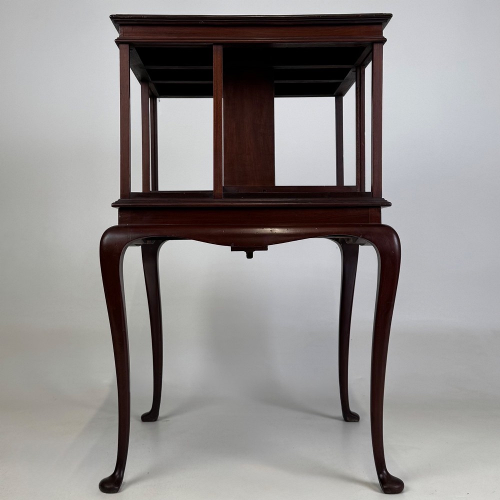 A dark mahogany revolving bookcase featuring a two-tier rotating upper section supported by slender cabriole legs ending in pad feet. View III