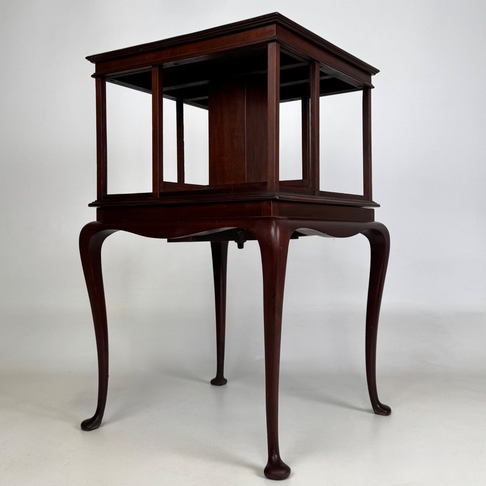 A dark mahogany revolving bookcase featuring a two-tier rotating upper section supported by slender cabriole legs ending in pad feet. View IV