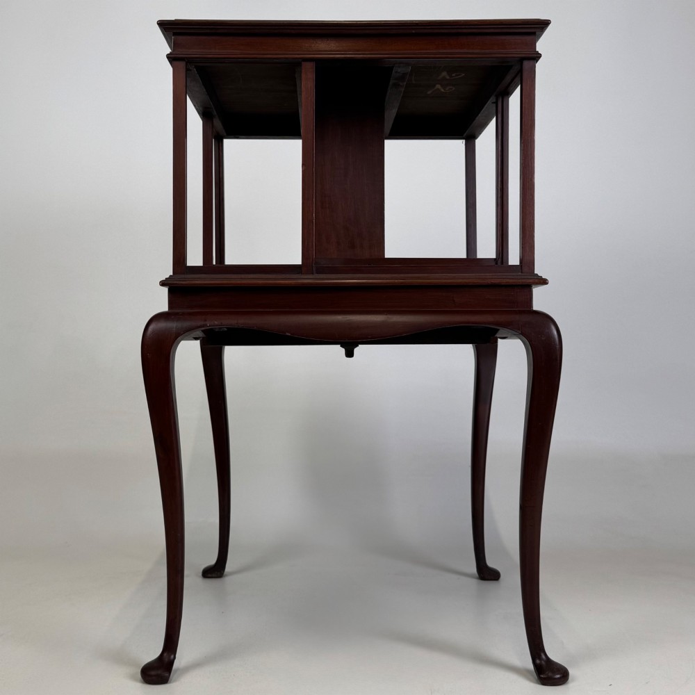 A dark mahogany revolving bookcase featuring a two-tier rotating upper section supported by slender cabriole legs ending in pad feet. View V