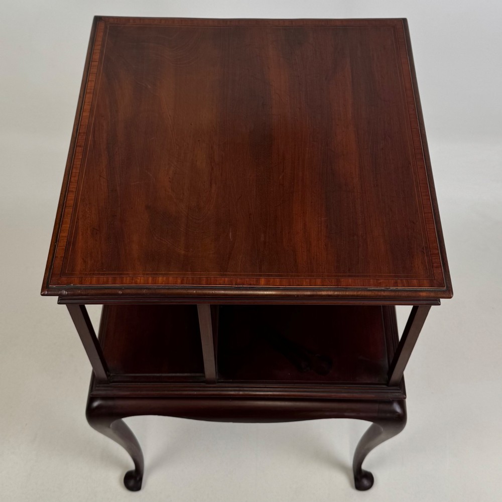 A dark mahogany revolving bookcase featuring a two-tier rotating upper section supported by slender cabriole legs ending in pad feet. View VII