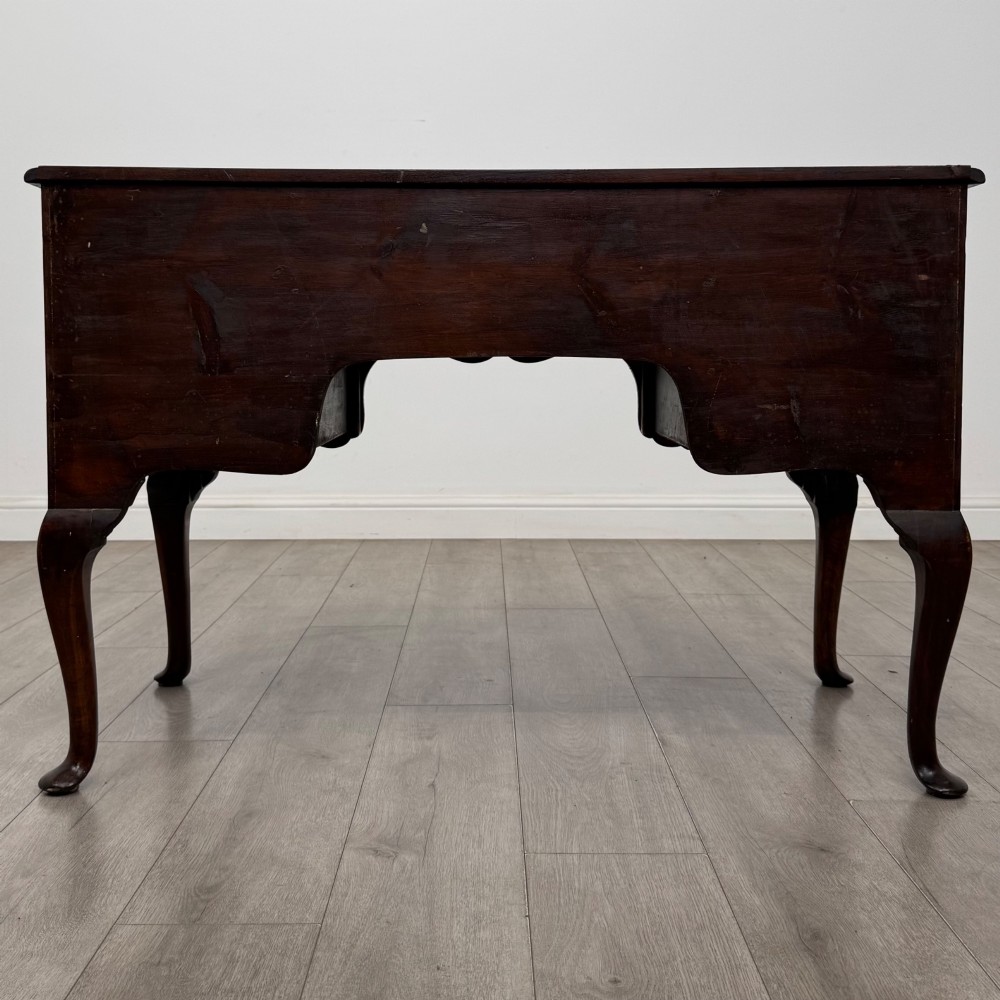 A 19th-century Victorian writing table crafted from burr walnut with five drawer fronts, ornate brass drop handles, a shaped central kneehole, and cabriole legs. View V