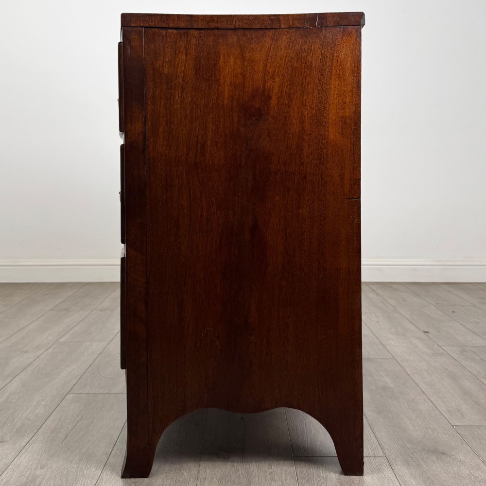 An 18th-century Georgian mahogany bow-front chest of drawers featuring two short over two long drawers with brass oval handles and splayed bracket feet. View III
