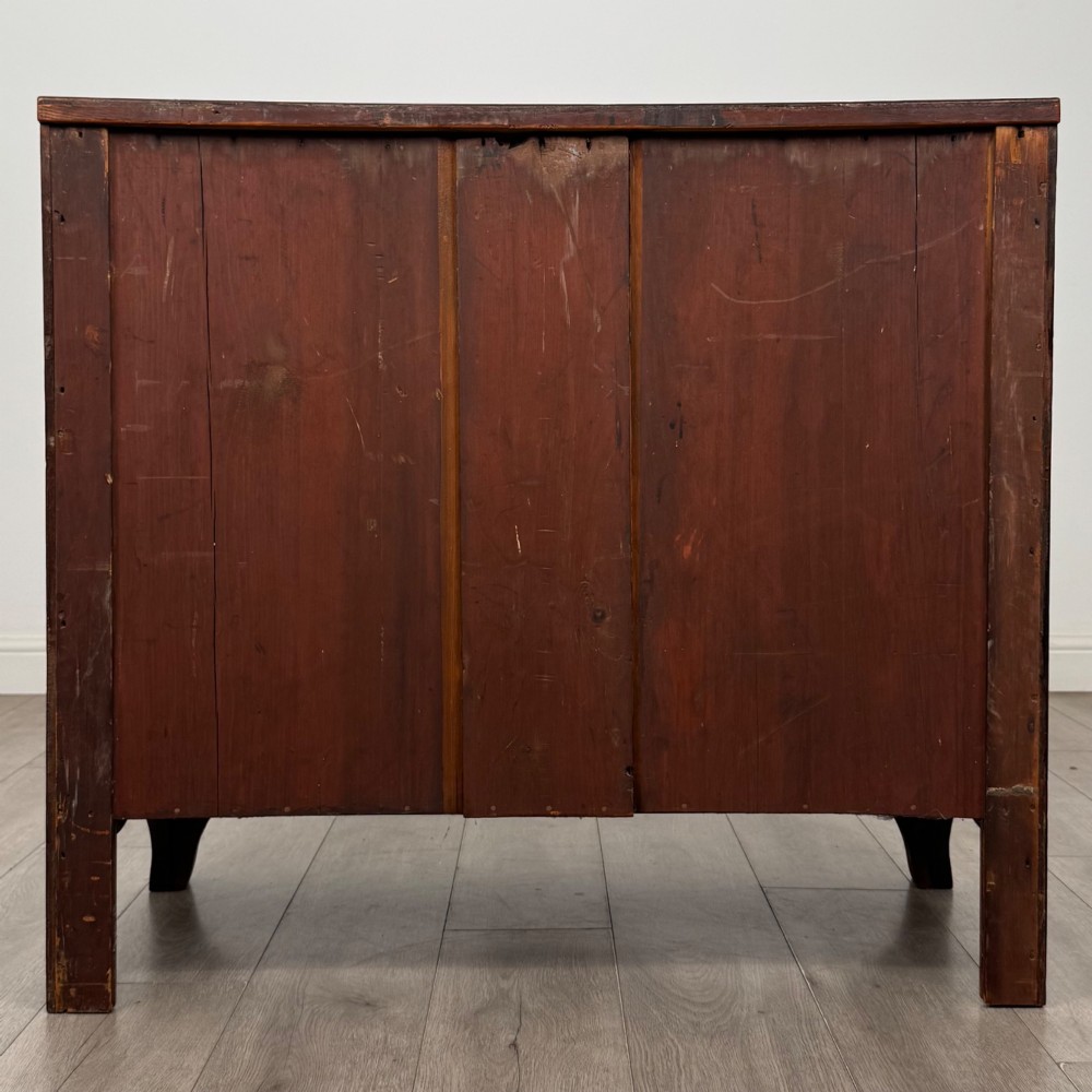 An 18th-century Georgian mahogany bow-front chest of drawers featuring two short over two long drawers with brass oval handles and splayed bracket feet. View V