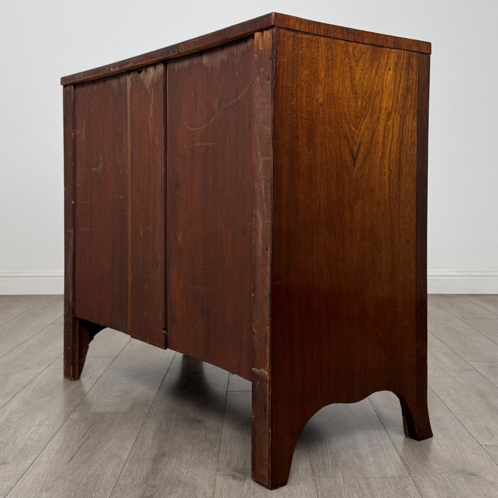 An 18th-century Georgian mahogany bow-front chest of drawers featuring two short over two long drawers with brass oval handles and splayed bracket feet. View VI