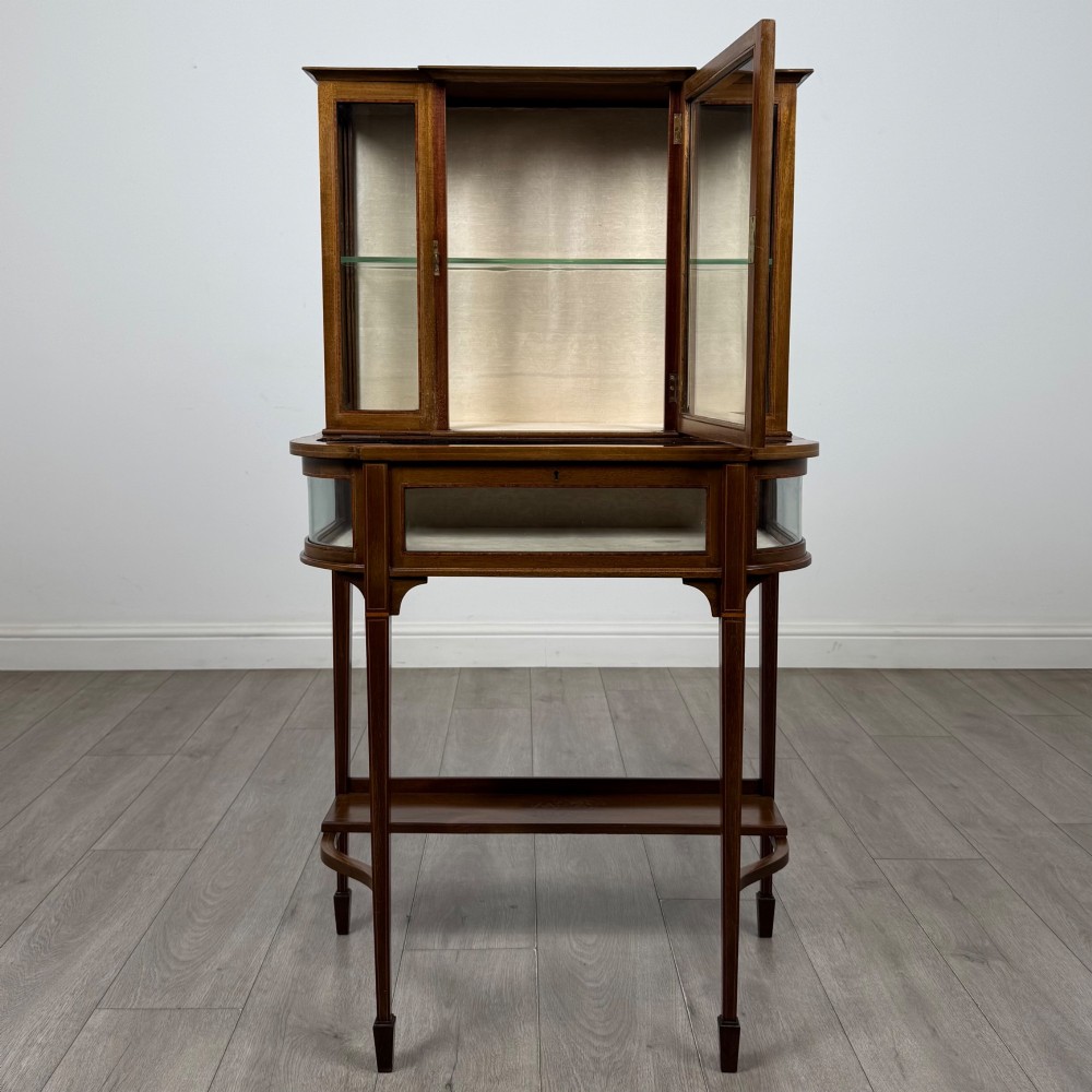 An Edwardian mahogany glazed display cabinet featuring tapered legs, line inlay detailing, glass shelves, and a lower undertier shelf. View II
