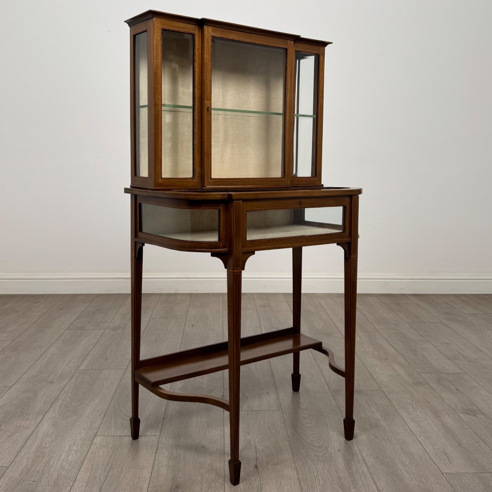 An Edwardian mahogany glazed display cabinet featuring tapered legs, line inlay detailing, glass shelves, and a lower undertier shelf. View IX