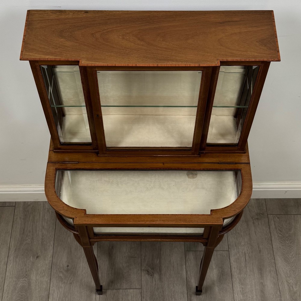 An Edwardian mahogany glazed display cabinet featuring tapered legs, line inlay detailing, glass shelves, and a lower undertier shelf. View X