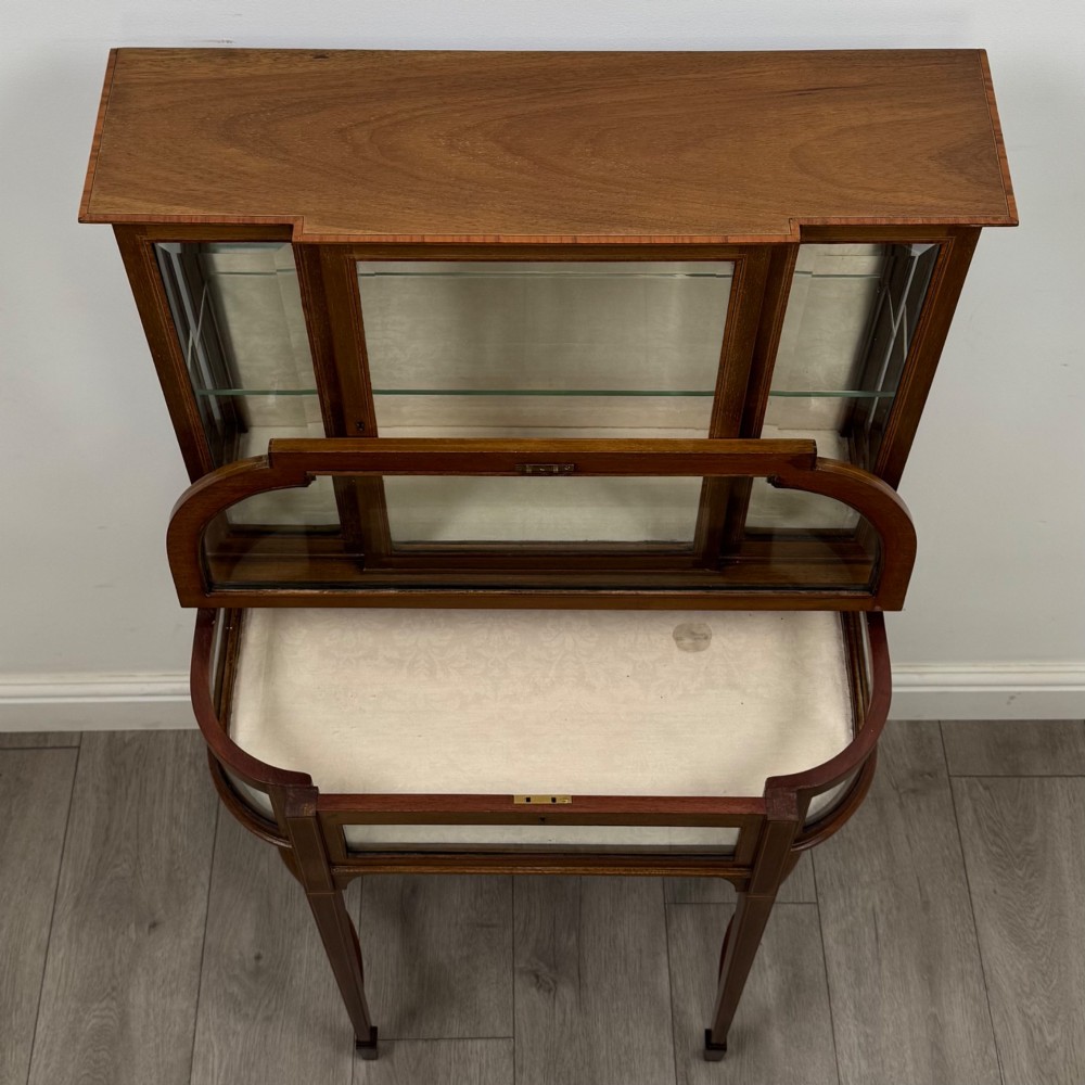 An Edwardian mahogany glazed display cabinet featuring tapered legs, line inlay detailing, glass shelves, and a lower undertier shelf. View XI