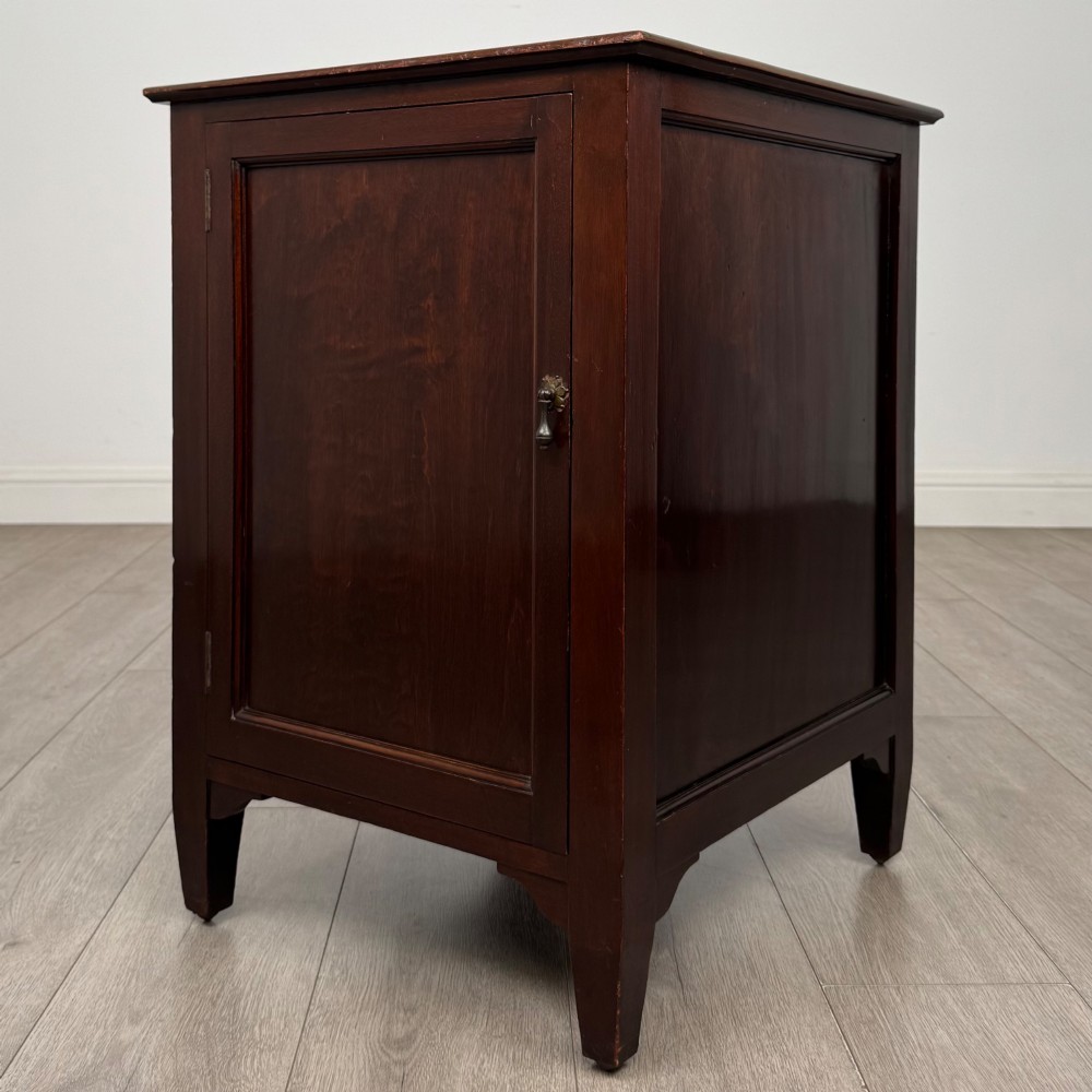A dark stained oak Edwardian cupboard featuring a single panel door, teardrop handle, and square tapered legs. View III
