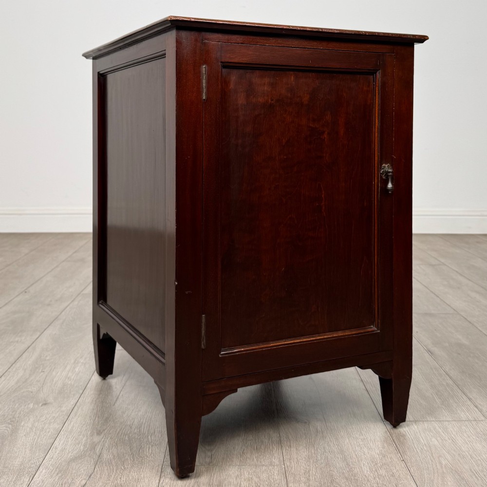 A dark stained oak Edwardian cupboard featuring a single panel door, teardrop handle, and square tapered legs. View IX