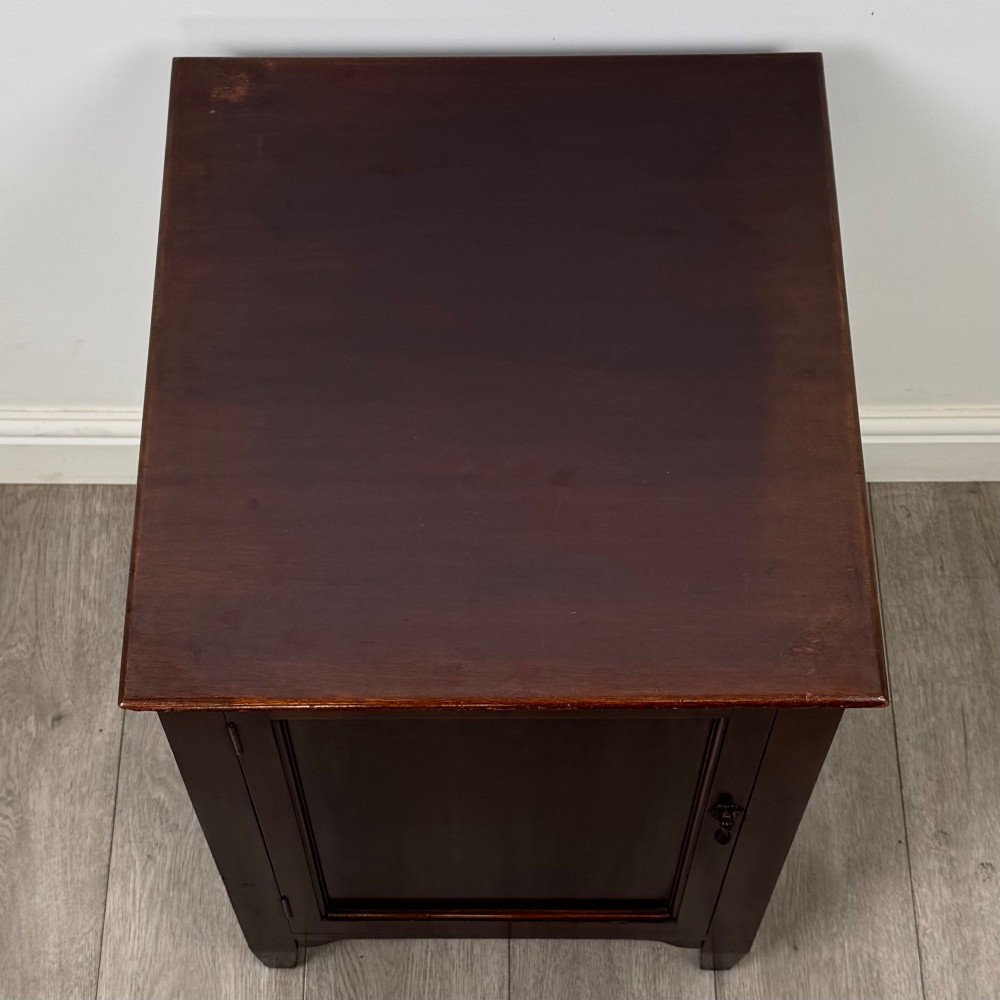 A dark stained oak Edwardian cupboard featuring a single panel door, teardrop handle, and square tapered legs. View X