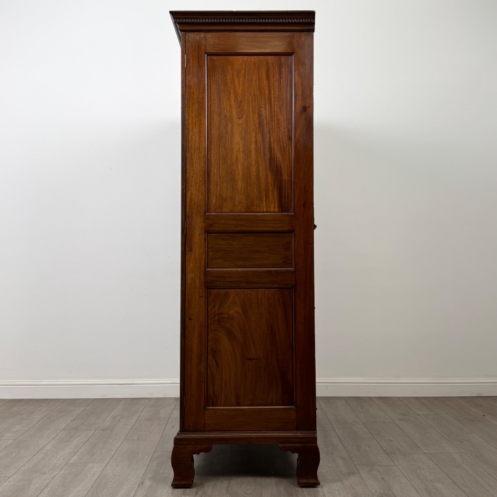 An 18th-century Georgian mahogany two-door wardrobe featuring fielded panel doors, a dentil-moulded cornice, and shaped bracket feet. View IV