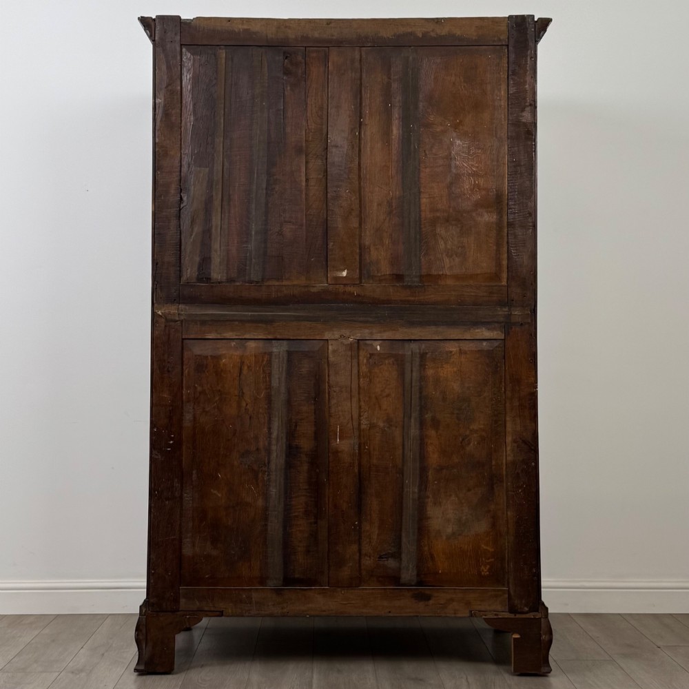 An 18th-century Georgian mahogany two-door wardrobe featuring fielded panel doors, a dentil-moulded cornice, and shaped bracket feet. View VI