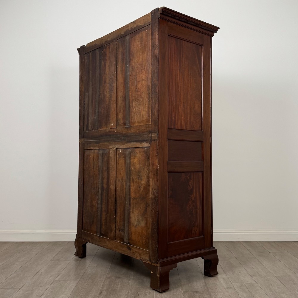 An 18th-century Georgian mahogany two-door wardrobe featuring fielded panel doors, a dentil-moulded cornice, and shaped bracket feet. View VII