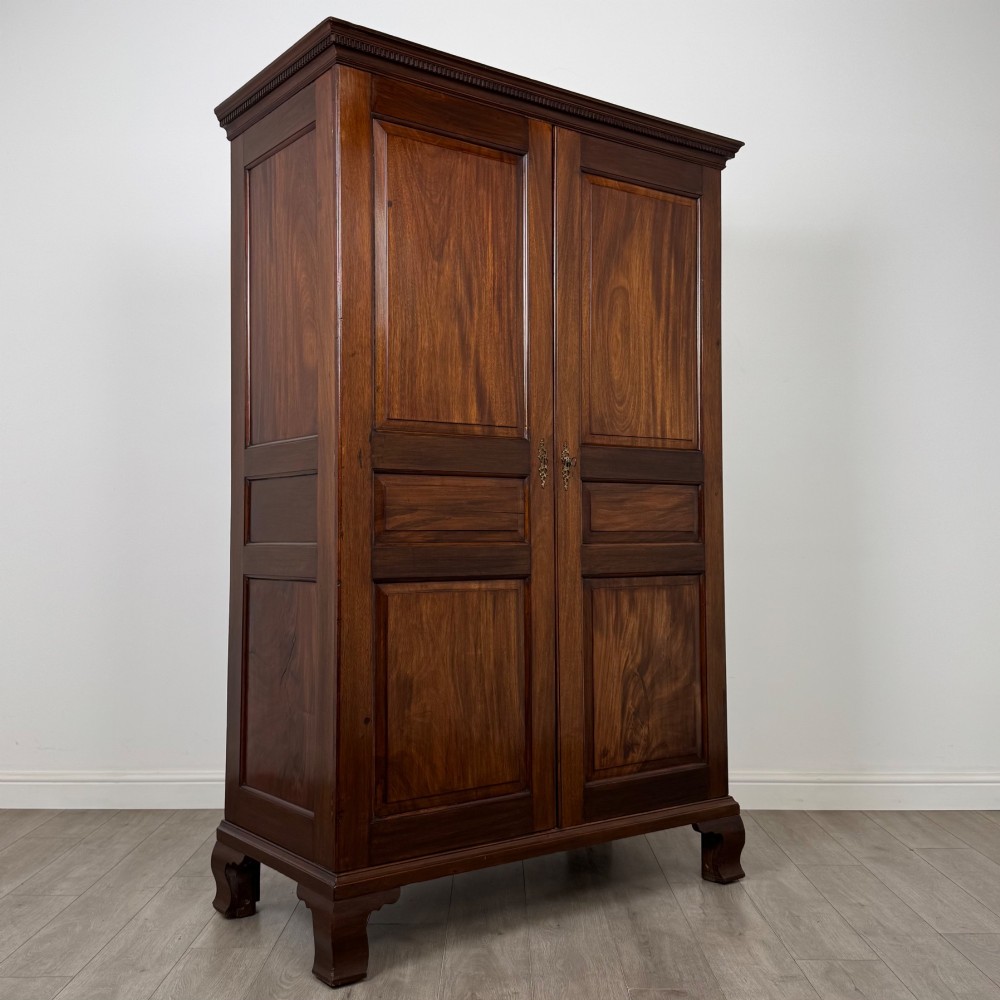 An 18th-century Georgian mahogany two-door wardrobe featuring fielded panel doors, a dentil-moulded cornice, and shaped bracket feet. View IX