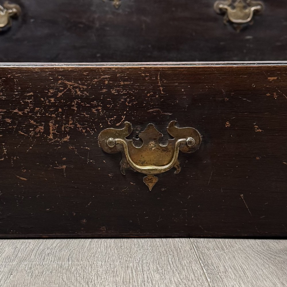 An 18th-century dark oak Georgian bureau with a slant-front writing slope, brass batwing drop handles, and bracket feet. View XIV