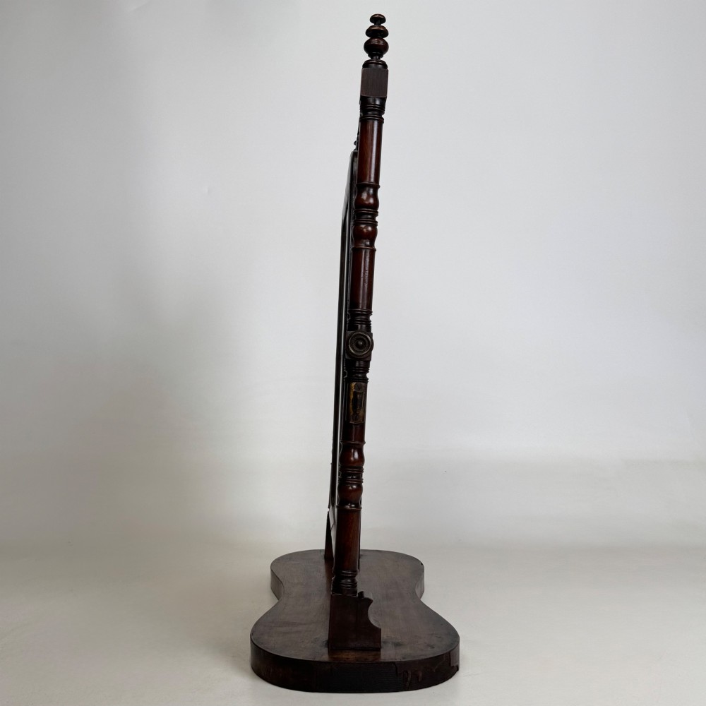 A 19th-century mahogany dressing mirror with turned side columns, carved scrollwork cresting, and an adjustable rectangular glass frame on a shaped base. View IV