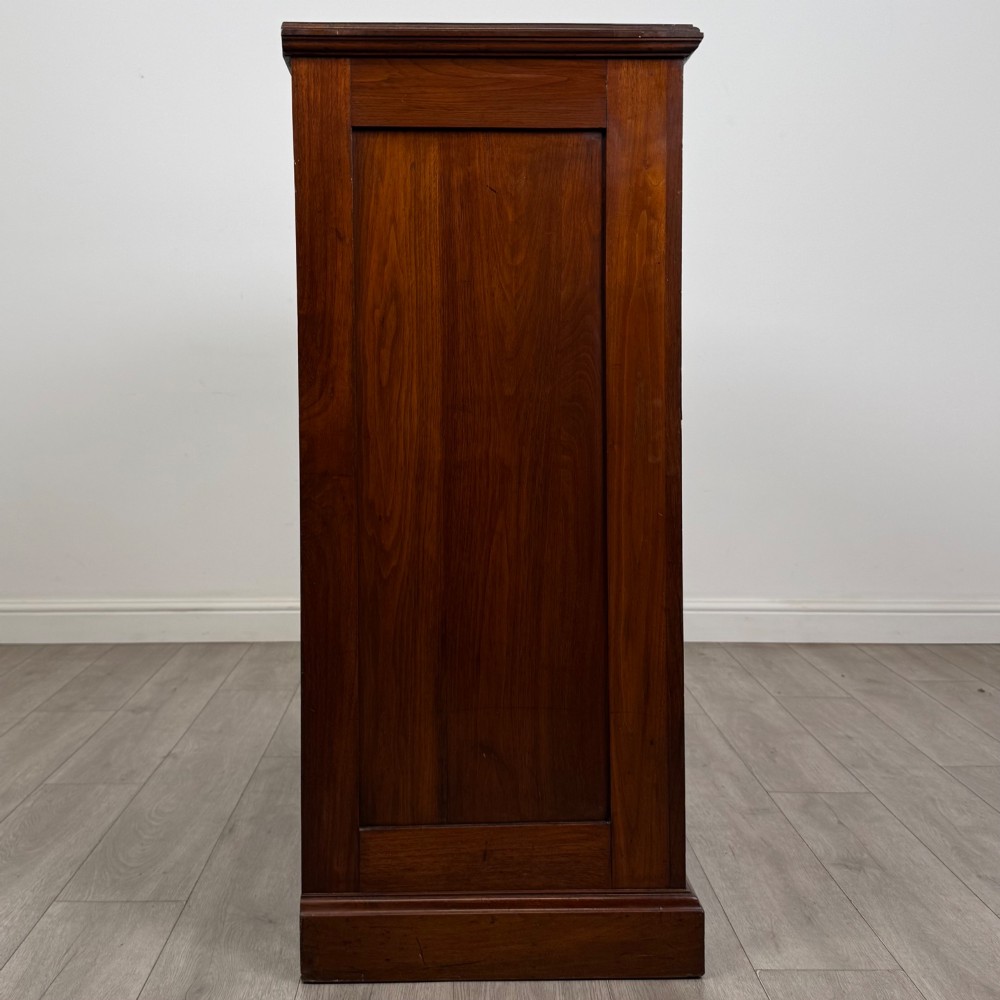 An Edwardian walnut chest of drawers featuring a two over three drawer layout with brass drop handles and a solid plinth base. View VII