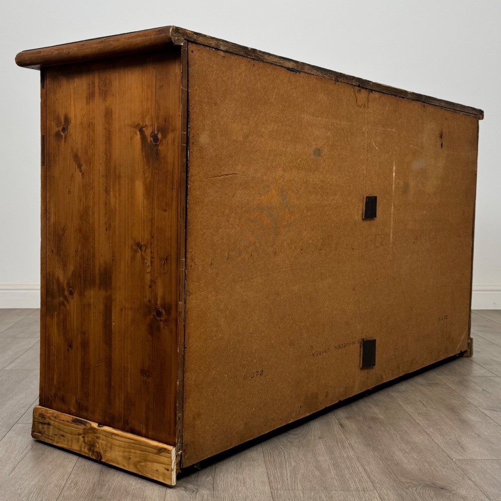 A 19th-century pine farmhouse dresser base featuring three upper drawers above two cupboard doors and an open central shelf. View V
