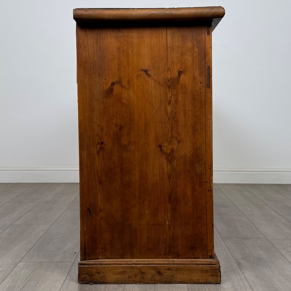 A 19th-century pine farmhouse dresser base featuring three upper drawers above two cupboard doors and an open central shelf. View VIII