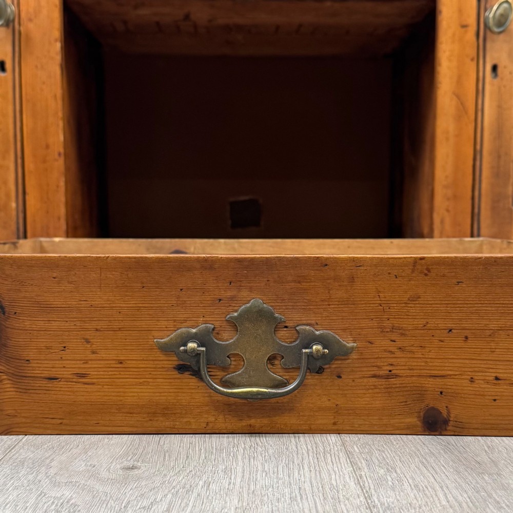 A 19th-century pine farmhouse dresser base featuring three upper drawers above two cupboard doors and an open central shelf. View XII