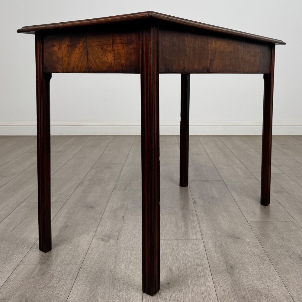 A dark mahogany Georgian style writing table featuring two frieze drawers with turned wood knobs and straight legs. View IV