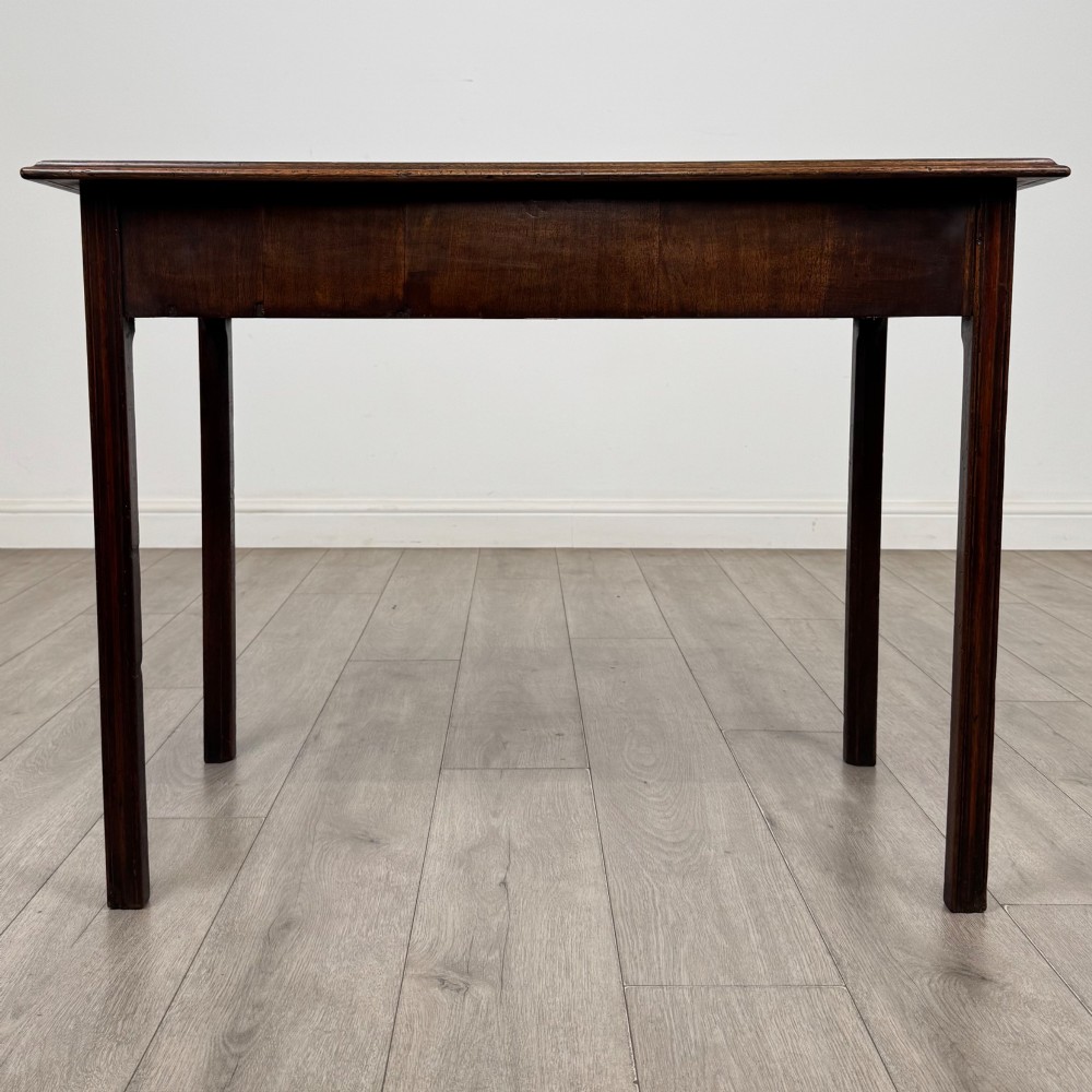 A dark mahogany Georgian style writing table featuring two frieze drawers with turned wood knobs and straight legs. View V
