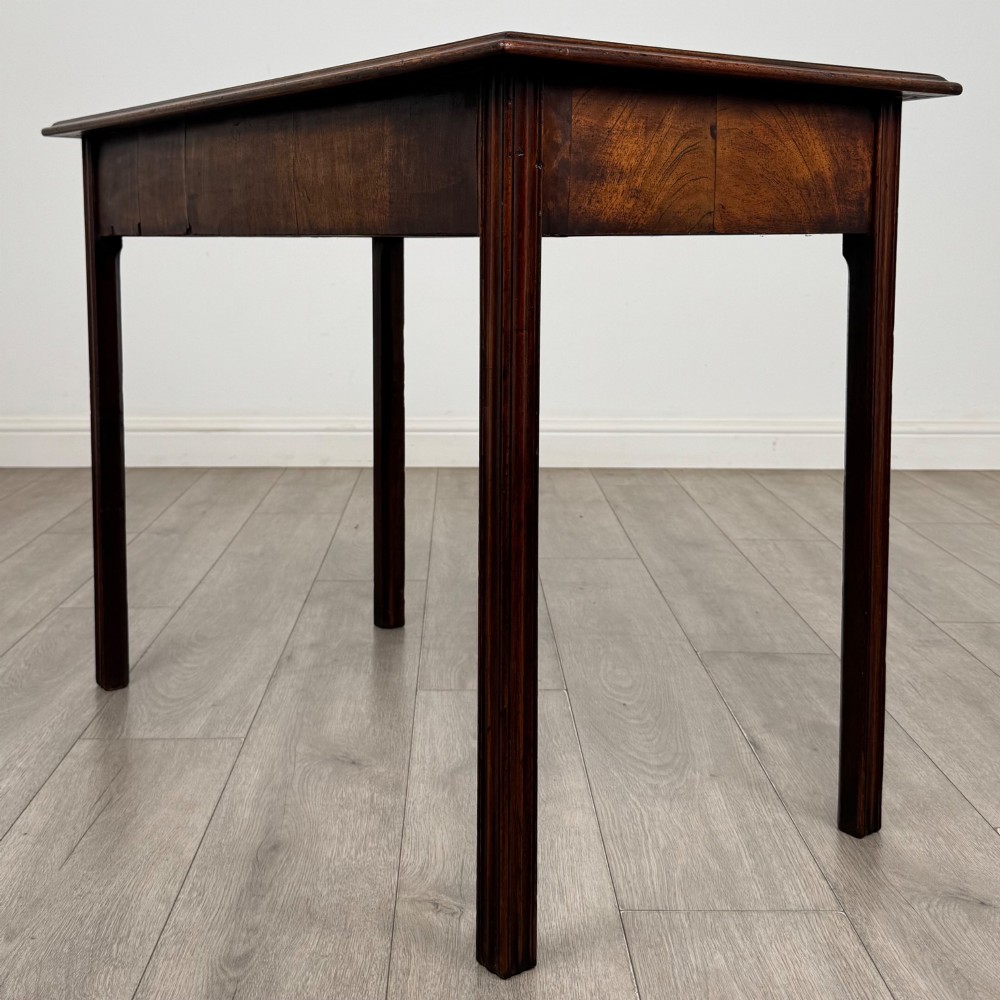 A dark mahogany Georgian style writing table featuring two frieze drawers with turned wood knobs and straight legs. View VI