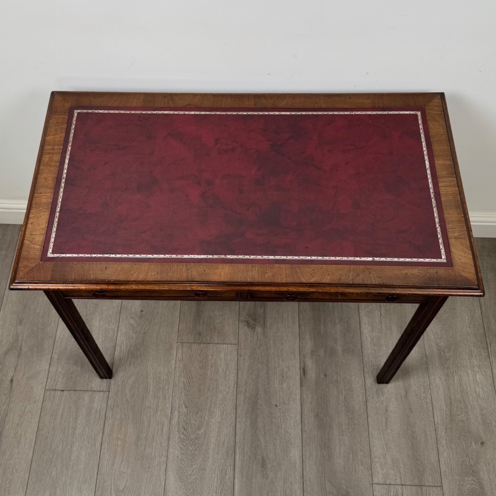 A dark mahogany Georgian style writing table featuring two frieze drawers with turned wood knobs and straight legs. View IX