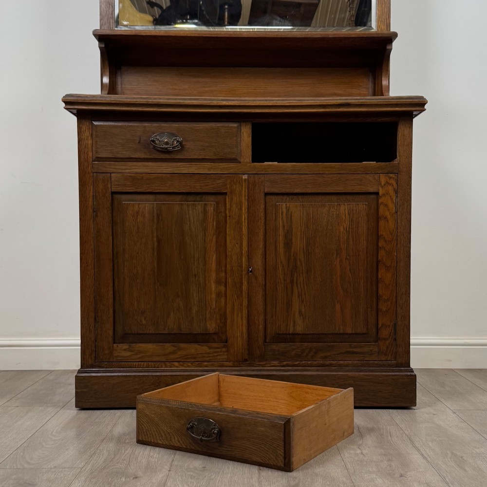 An early 20th-century warm brown oak mirror back sideboard featuring two drawers, a double-door cupboard base, and an elevated mirror plate cresting. View XI