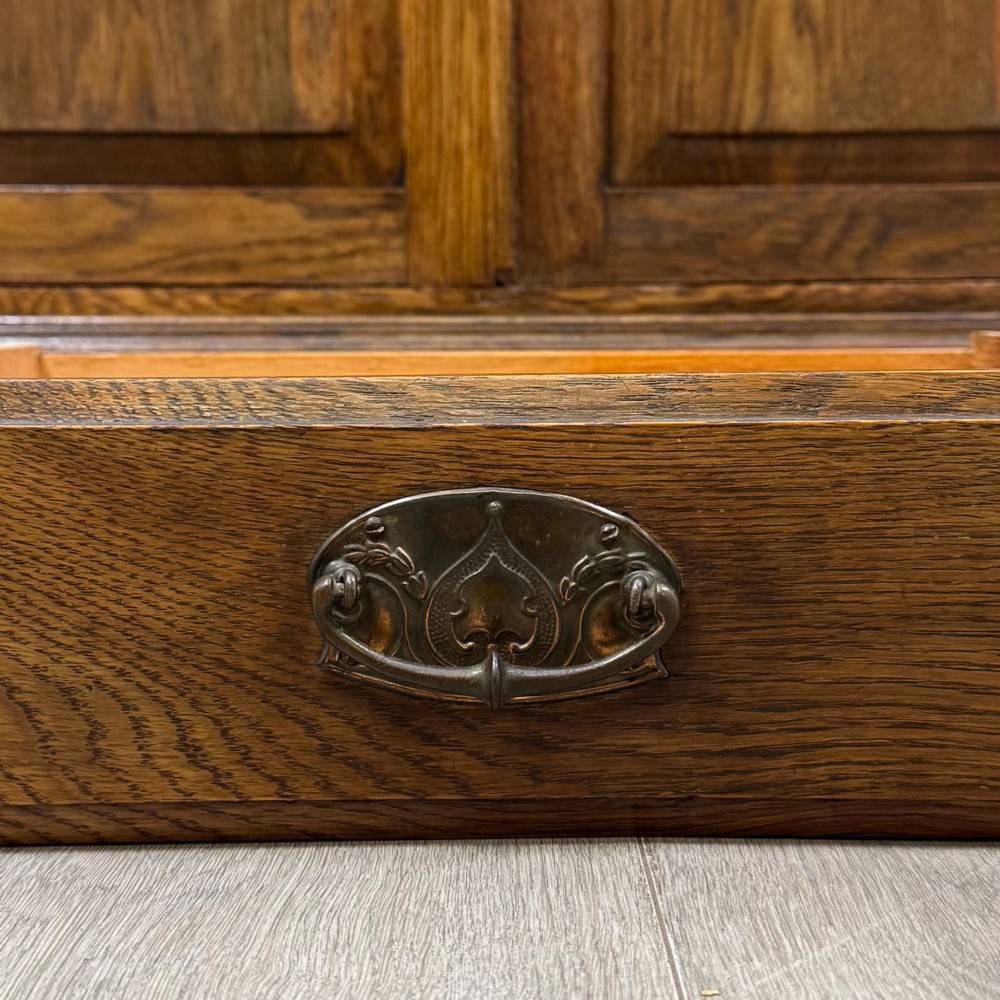 An early 20th-century warm brown oak mirror back sideboard featuring two drawers, a double-door cupboard base, and an elevated mirror plate cresting. View XII