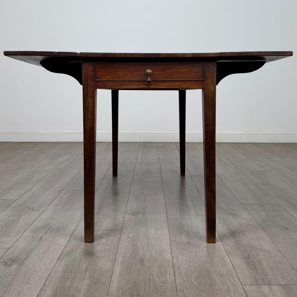 A 19th-century Georgian style dark mahogany Pembroke side table with drop leaves, tapered square legs, and a single frieze drawer with a brass drop handle. View V