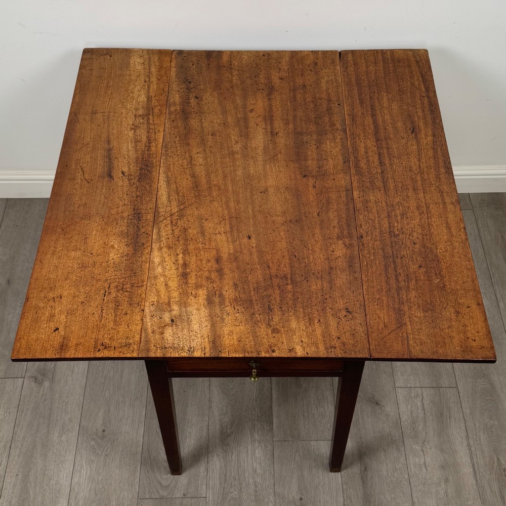 A 19th-century Georgian style dark mahogany Pembroke side table with drop leaves, tapered square legs, and a single frieze drawer with a brass drop handle. View XI