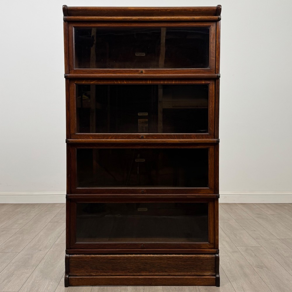 An early twentieth-century oak four-tier Globe Wernicke stacking bookcase featuring glazed lift-and-slide doors.