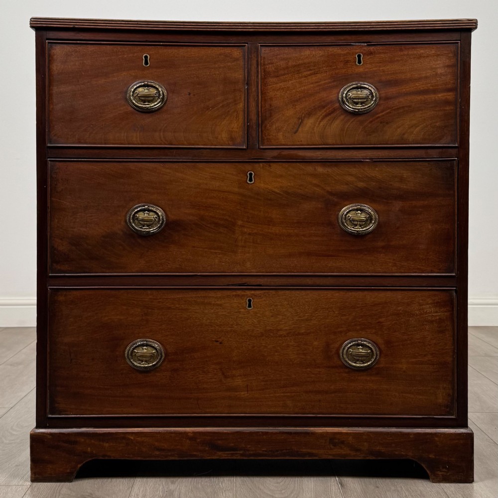 An eighteenth-century Georgian mahogany chest of drawers featuring two short upper drawers above two long lower drawers with oval brass handles.