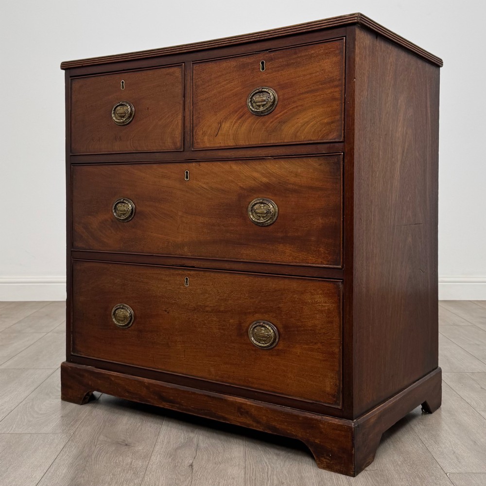 An eighteenth-century Georgian mahogany chest of drawers featuring two short upper drawers above two long lower drawers with oval brass handles. View II
