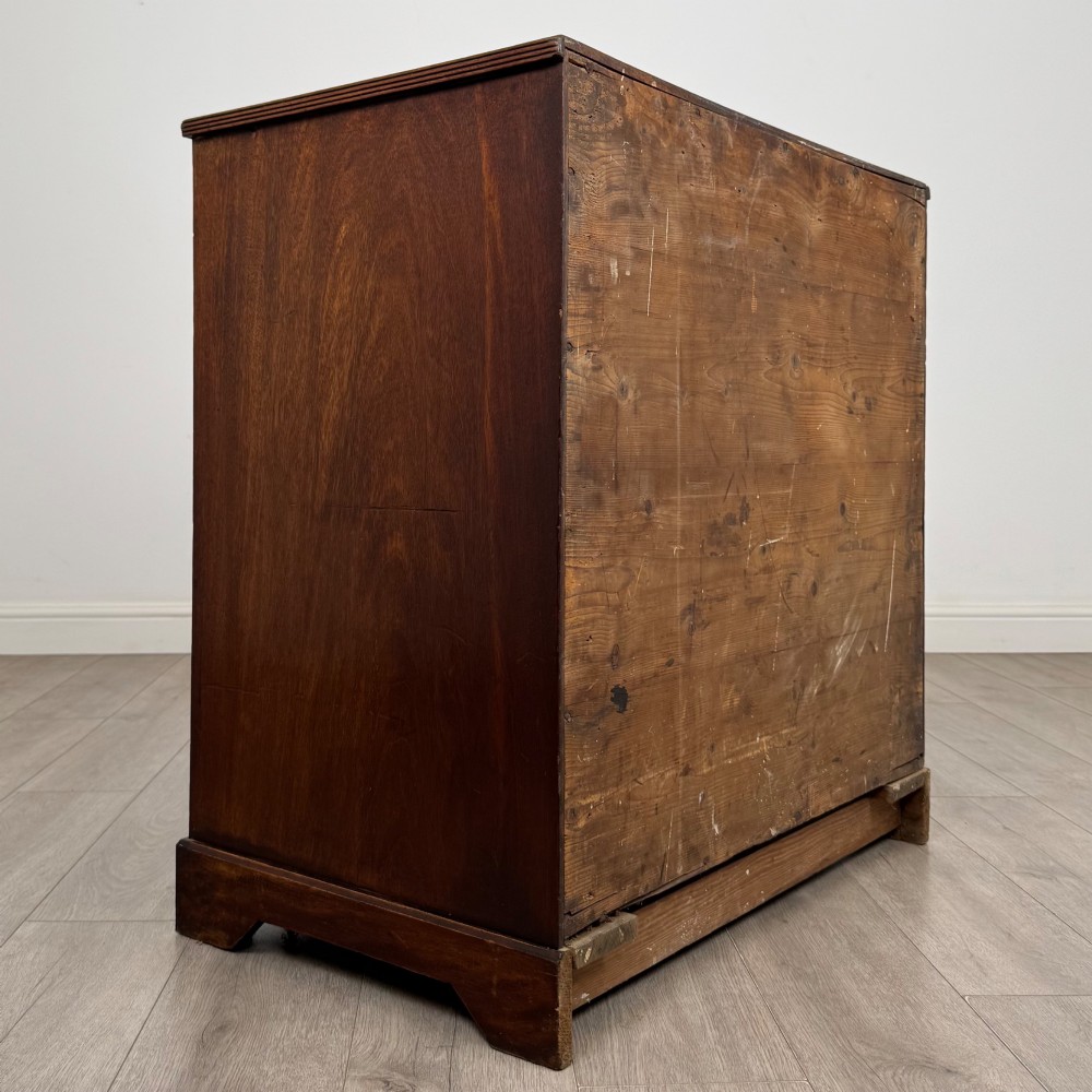 An eighteenth-century Georgian mahogany chest of drawers featuring two short upper drawers above two long lower drawers with oval brass handles. View IV