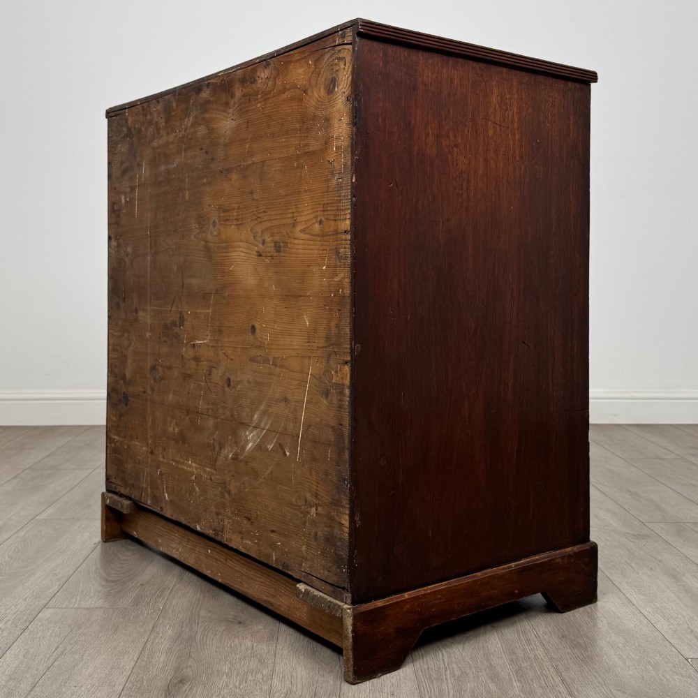 An eighteenth-century Georgian mahogany chest of drawers featuring two short upper drawers above two long lower drawers with oval brass handles. View VI