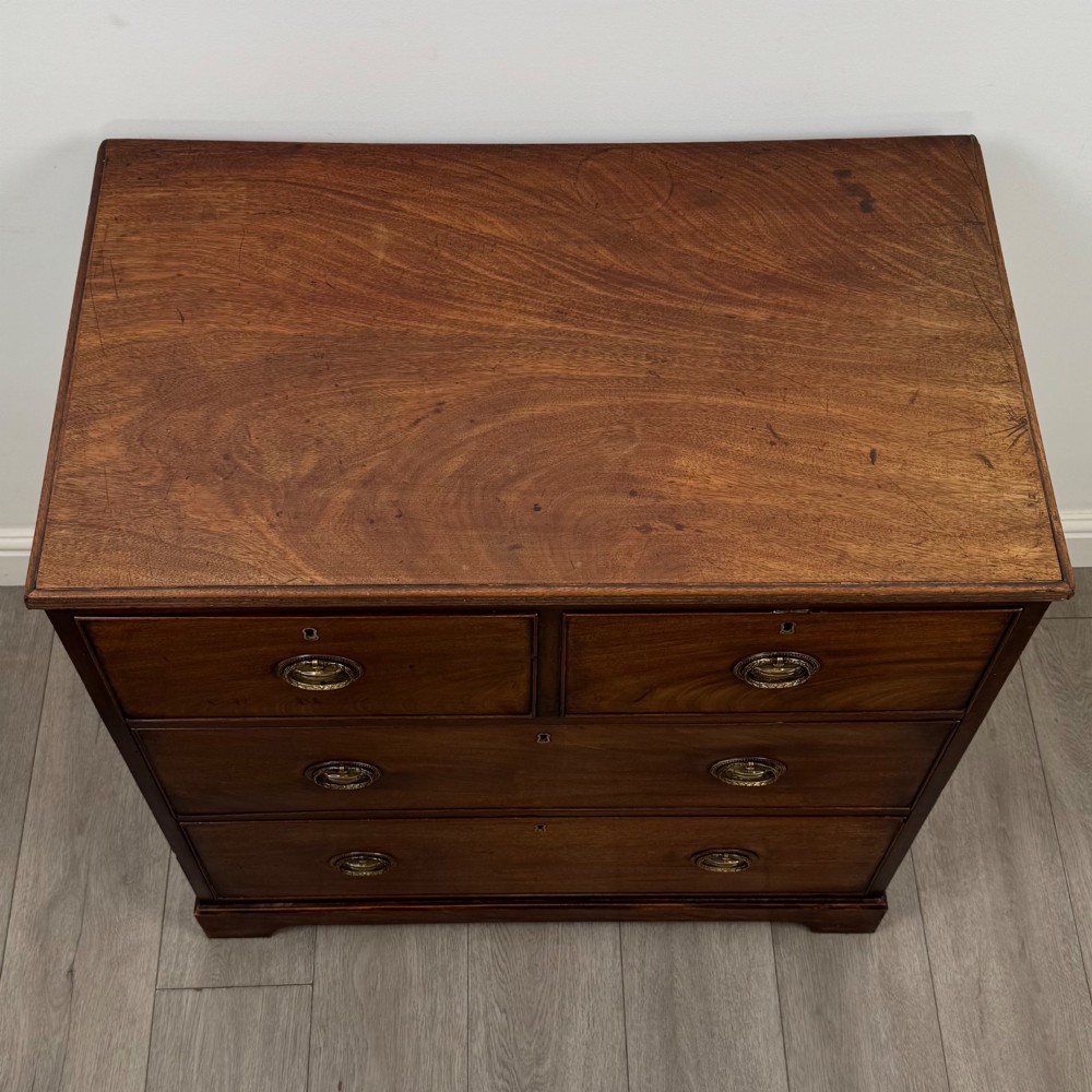 An eighteenth-century Georgian mahogany chest of drawers featuring two short upper drawers above two long lower drawers with oval brass handles. View IX