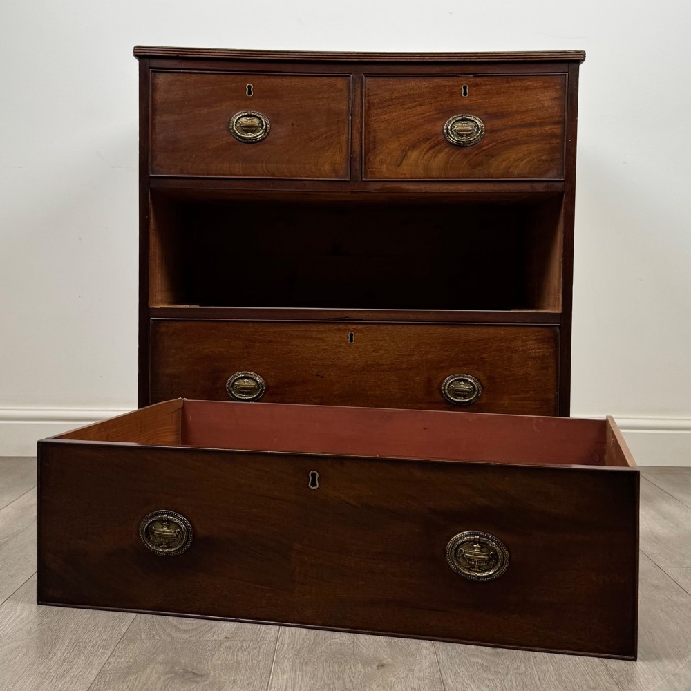 An eighteenth-century Georgian mahogany chest of drawers featuring two short upper drawers above two long lower drawers with oval brass handles. View X