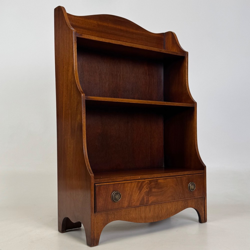 A small 20th-century mahogany open bookcase with a shaped top gallery, two open shelves, and a single lower drawer fitted with brass ring handles. View IX