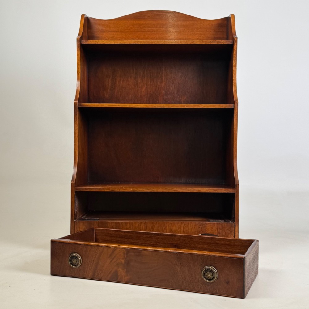 A small 20th-century mahogany open bookcase with a shaped top gallery, two open shelves, and a single lower drawer fitted with brass ring handles. View X