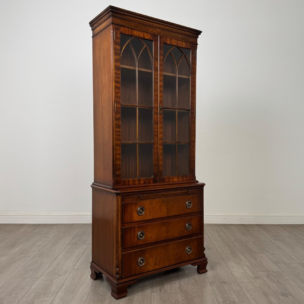 A tall Georgian style mahogany bookcase featuring two glazed doors with gothic arch tracery above a lower section with three drawers. View X