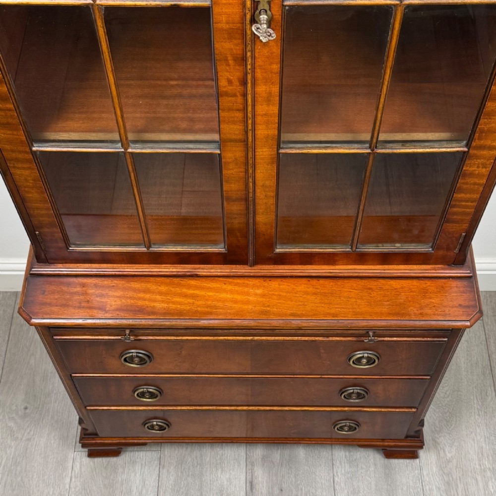 A tall Georgian style mahogany bookcase featuring two glazed doors with gothic arch tracery above a lower section with three drawers. View XI