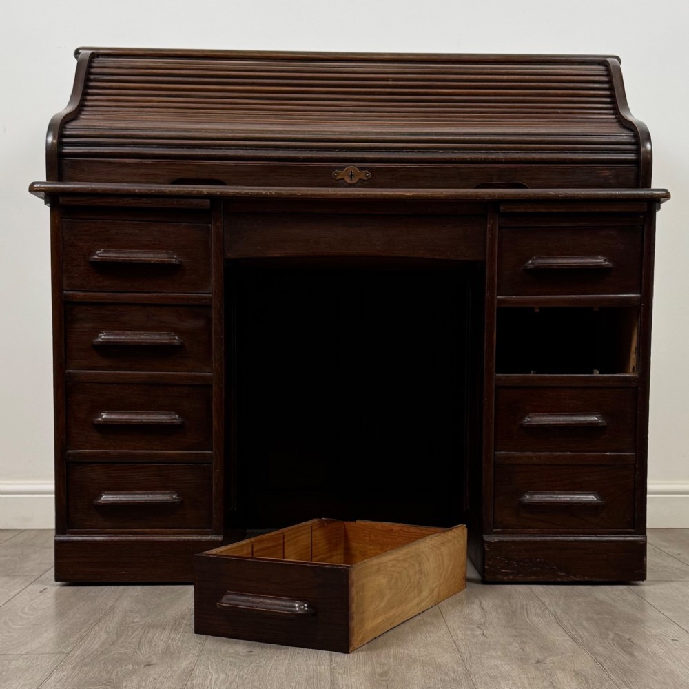 An Edwardian dark oak roll top desk featuring a slatted tambour front above a twin pedestal base with eight drawers. View XIII