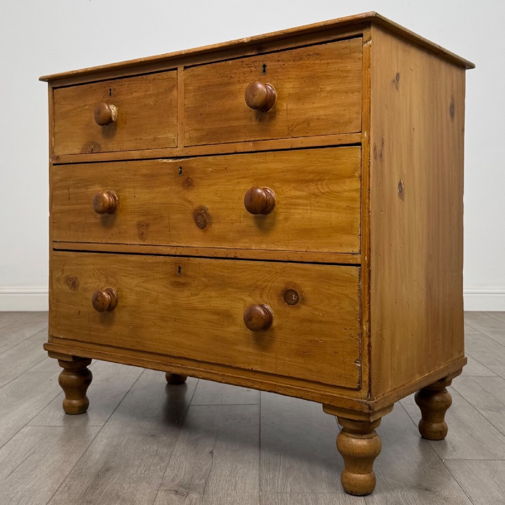 A Victorian pine chest of drawers featuring a two over two drawer layout, turned wooden knobs, and turned feet. View II