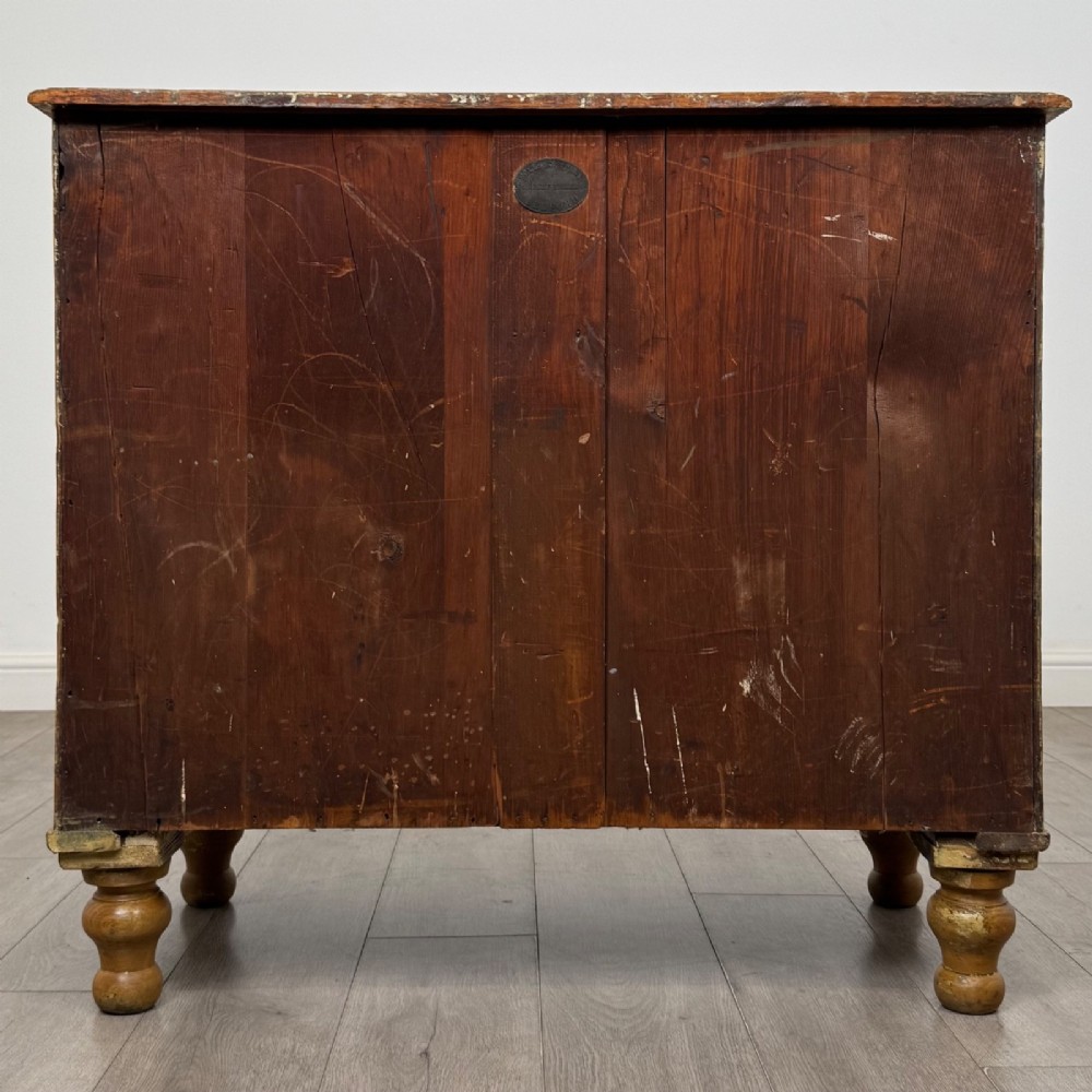 A Victorian pine chest of drawers featuring a two over two drawer layout, turned wooden knobs, and turned feet. View V