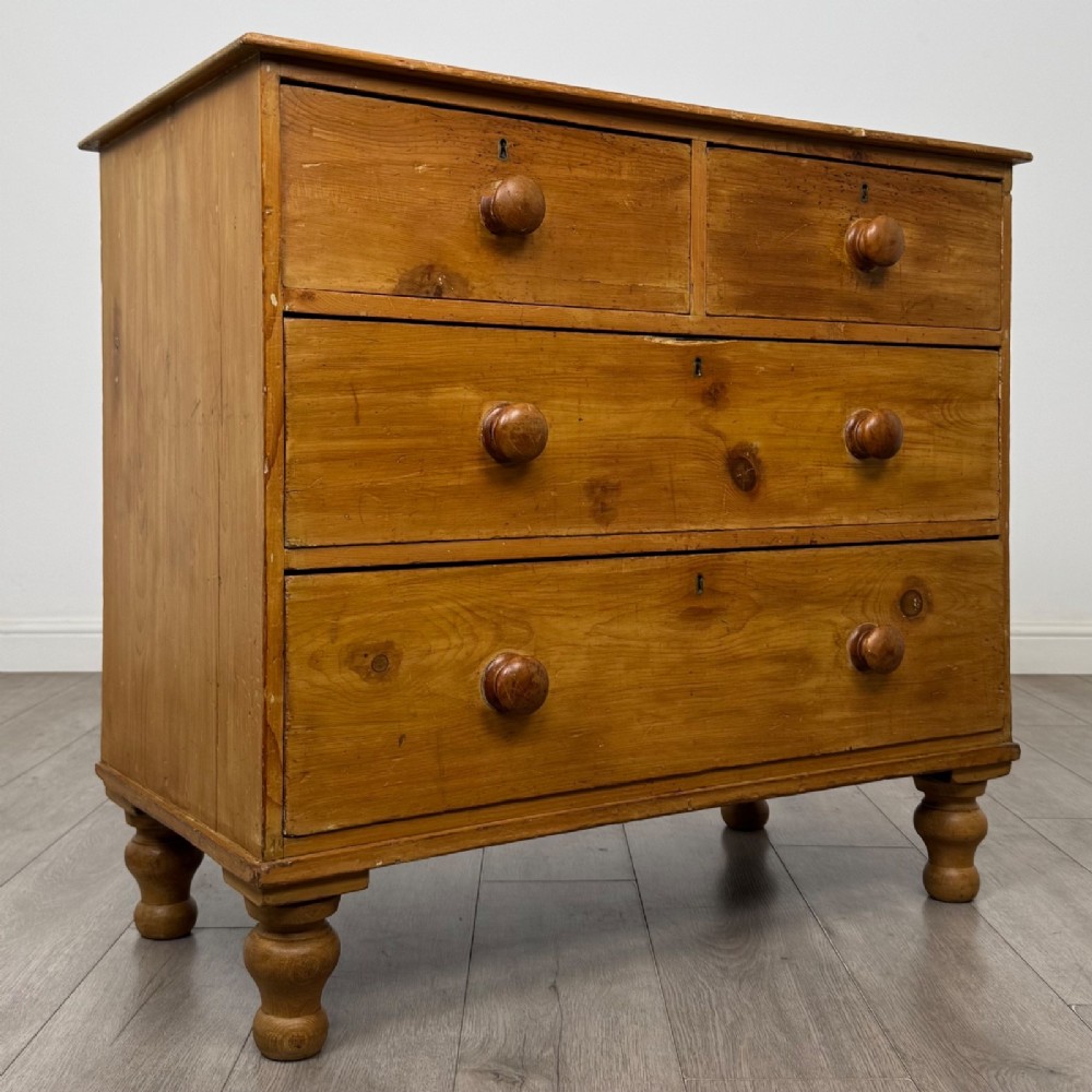 A Victorian pine chest of drawers featuring a two over two drawer layout, turned wooden knobs, and turned feet. View VIII